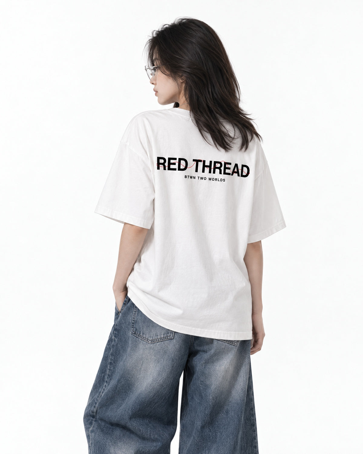 Red Thread Between Two Worlds heavyweight tee in white, worn by a female model
