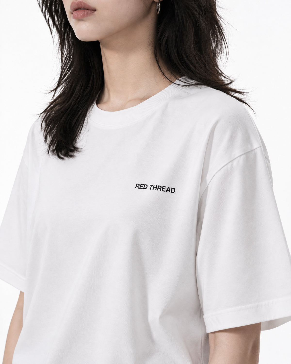 Red Thread Between Two Worlds heavyweight tee in white, worn by a female model