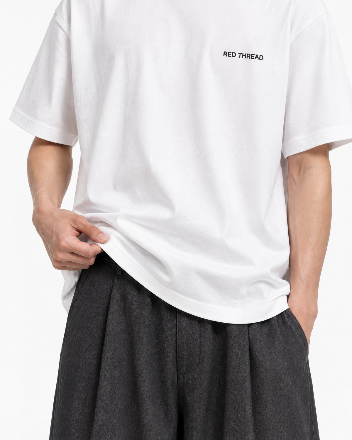 Red Thread Between Two Worlds heavyweight tee in white, worn by a male model